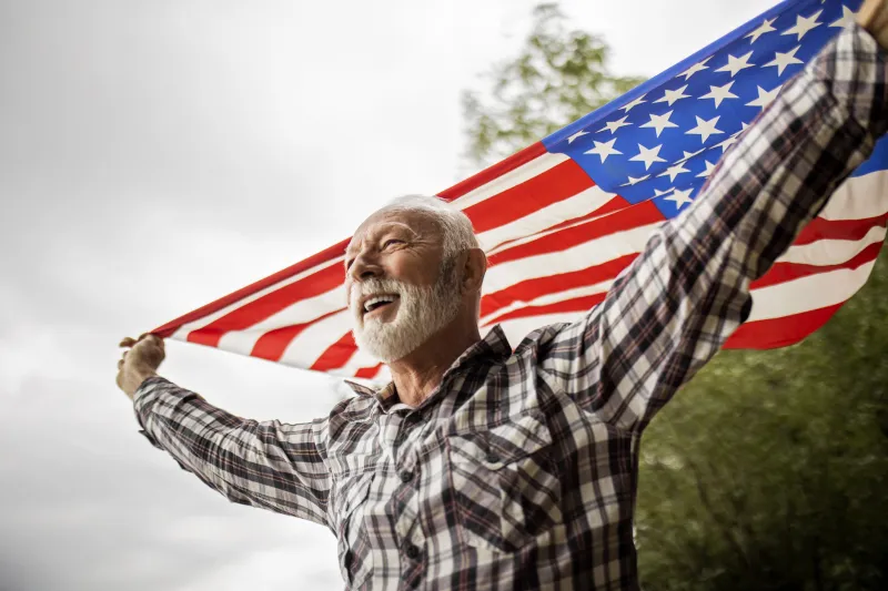 Senior man holding an American flag.