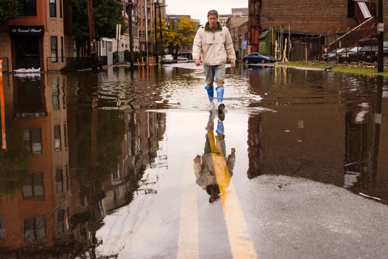 Man walking in a water covered street after a storm 