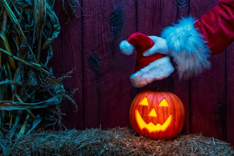 Santa putting his hat on a pumpkin