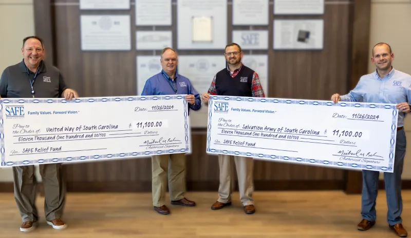 from left to right: Keith Troup, Alan Lewis, Michael Baker, Drew Huckeba holding donation checks to Salvation Army and United Way