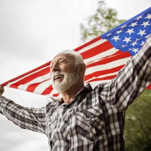 Senior man holding an American flag.